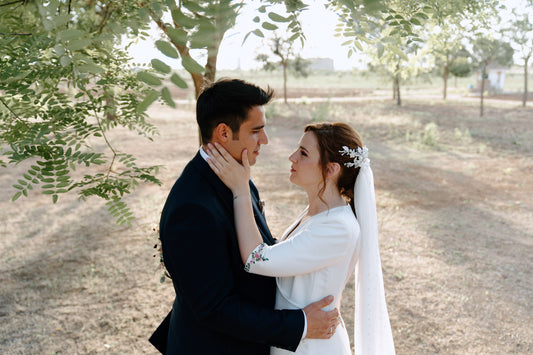 Novios abrazados en una boda en ciudad real con la puesta de sol al fondo