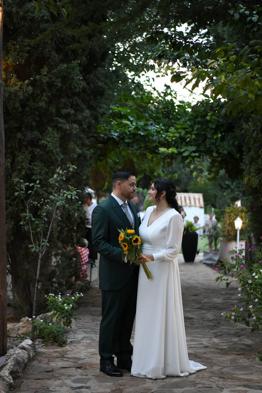 Pareja de novios mirándose a la entrada de la finca familiar donde se casaron
